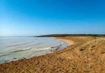 Paesaggio costiero con dune di sabbia, mare e cielo blu