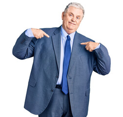 Senior grey-haired man wearing business jacket looking confident with smile on face, pointing oneself with fingers proud and happy.