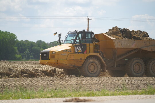 Caterpillar 735 construction dump trucks carrying dirt material to construct the land to expand highway 23 from fond du lac to Sheboygan.