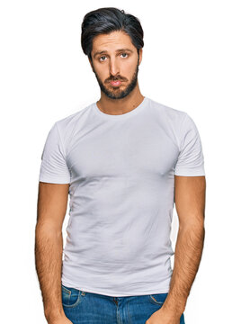Young hispanic man wearing casual white t shirt depressed and worry for distress, crying angry and afraid. sad expression.