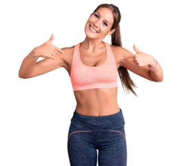 Young beautiful hispanic woman wearing sportswear looking confident with smile on face, pointing oneself with fingers proud and happy.