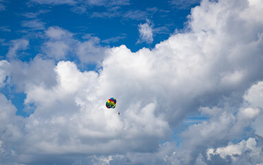 parasailing against blue sky rainbow colors