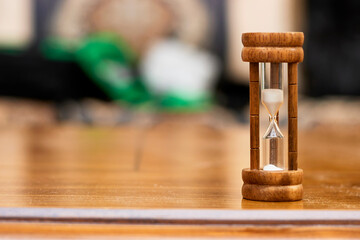 Sand running through the bulbs of an hourglass measuring the passing time in a countdown to a...