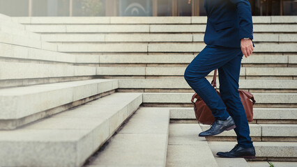 Climbing the steps to success. Profile shot of an unidentifiable businessman walking to work in the...