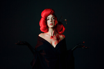A fighting geisha in a black kimono splashes blood on her face. Halloween image. young multiethnic...