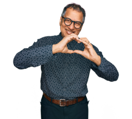Middle age indian man wearing casual clothes and glasses smiling in love doing heart symbol shape with hands. romantic concept.