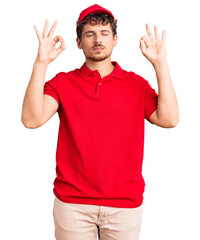 Young handsome man with curly hair wearing delivery uniform relax and smiling with eyes closed doing meditation gesture with fingers. yoga concept.