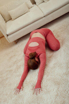 a woman does a yoga exercise at home lying on the floor