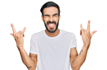 Young hispanic man wearing casual white t shirt shouting with crazy expression doing rock symbol with hands up. music star. heavy concept.