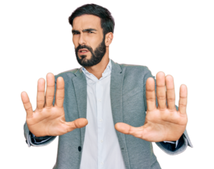 Young hispanic man wearing business clothes doing stop gesture with hands palms, angry and frustration expression