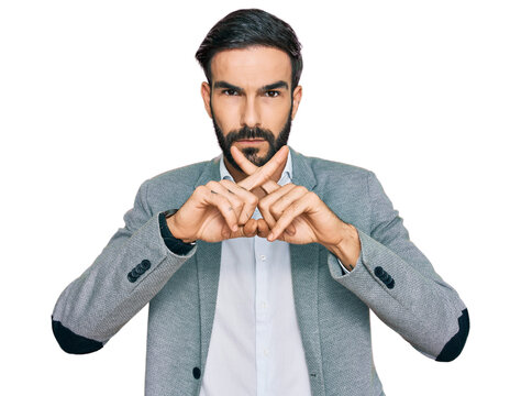 Young hispanic man wearing business clothes rejection expression crossing fingers doing negative sign