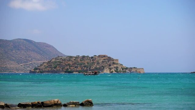 Spinalonga island, Crete, Greece. Tourists sail along the island in excursion boats. Spinalonga is the main local landmark.