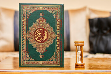 Quran - holy book of Muslims with arabic calligraphy and  hourglass as time passing concept. Life...