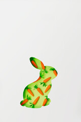Easter bunny greeting card, with copy space; Cut out bunny shape with small decorative carrots in the background