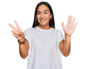 Young asian woman wearing casual white t shirt showing and pointing up with fingers number seven while smiling confident and happy.