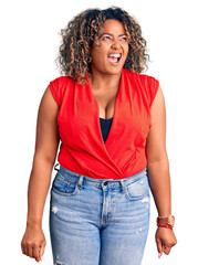 Young african american plus size woman wearing casual style with sleeveless shirt angry and mad screaming frustrated and furious, shouting with anger. rage and aggressive concept.