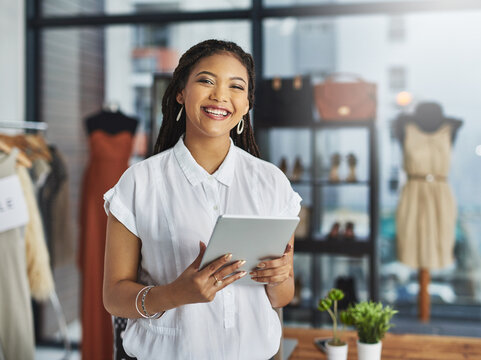 Few things satisfy me like working for myself. Cropped portrait of a young business owner using her tablet while standing in her store.