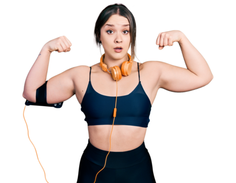 Young hispanic girl wearing sportswear doing strong gesture in shock face, looking skeptical and sarcastic, surprised with open mouth