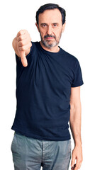 Middle age handsome man wearing casual t-shirt looking unhappy and angry showing rejection and negative with thumbs down gesture. bad expression.