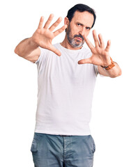 Middle age handsome man wearing casual t-shirt doing frame using hands palms and fingers, camera perspective