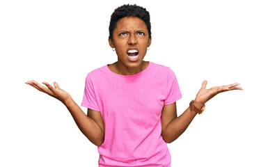 Young african american woman wearing casual clothes crazy and mad shouting and yelling with aggressive expression and arms raised. frustration concept.