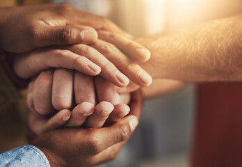 Many hands, one mind. Shot of a group of people putting their hands together.