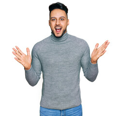 Fototapeta premium Young arab man wearing casual clothes celebrating crazy and amazed for success with arms raised and open eyes screaming excited. winner concept