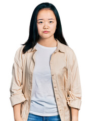 Young chinese woman wearing casual white t shirt and jacket depressed and worry for distress, crying angry and afraid. sad expression.