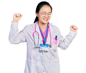 Fototapeta premium Young chinese woman wearing doctor uniform and stethoscope dancing happy and cheerful, smiling moving casual and confident listening to music