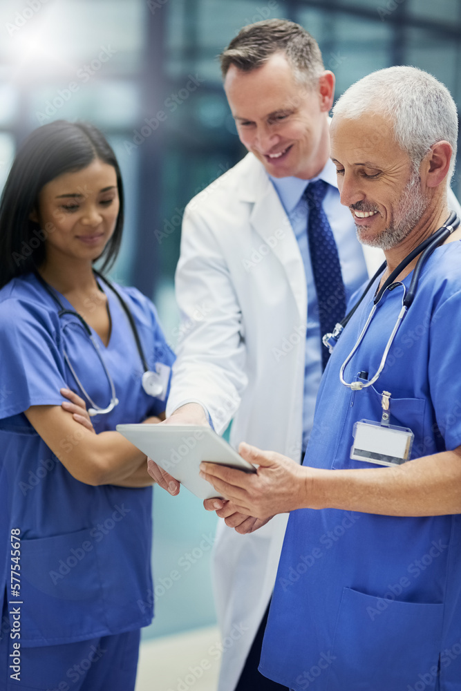 Poster saving lives on diagnosis at a time. shot of a group of doctors talking together over a digital tabl