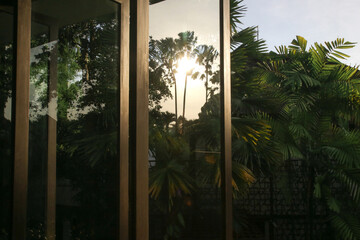 Open windows toward tropical garden during sunny afternoon
