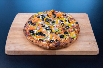 A delicious freshly baked greek pizza with feta cheese, olives, tomato, and green pepper.