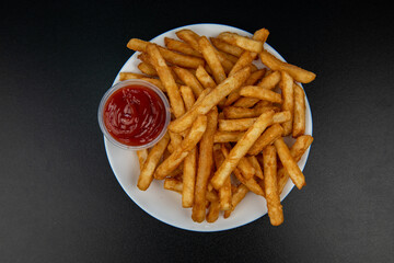 French fries with ketchup on dark background, top view