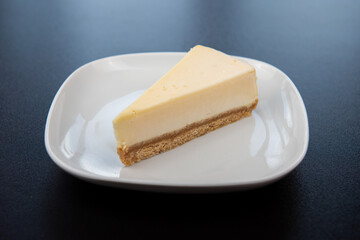 Plain cheesecakes on white plate on black background