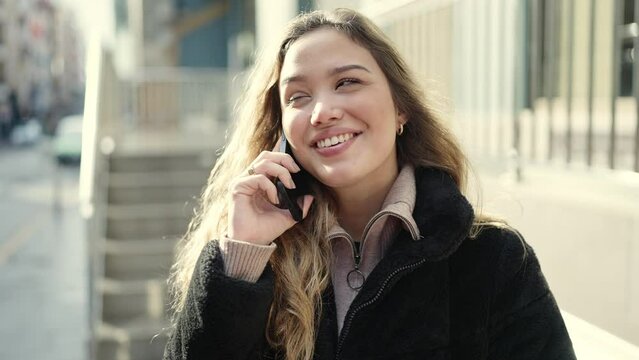 Young beautiful hispanic woman smiling confident talking on smartphone at street