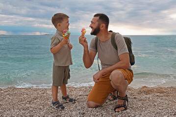 Summer vacation of happy family. Son and father eat ice cream at sea in Croatia.Summer vacation.Happy lifestyle childhood concept. - 577552615