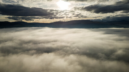 Aerial view of sunset over a bank of fog with distant mountains