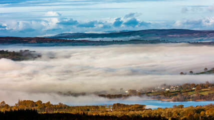 Low lying fog and cloud in a rural valley surrounded by farmland and fields (Brecon Beacons, Wales)
