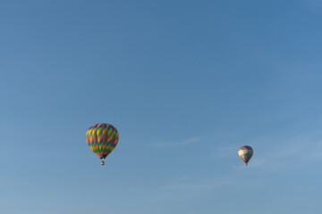 Fototapeta na wymiar Pair of hot air balloons floating in the air