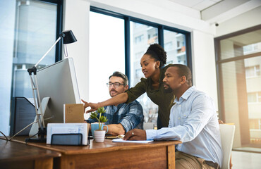 What about that. Cropped shot of three businesspeople working around a computer in the office.