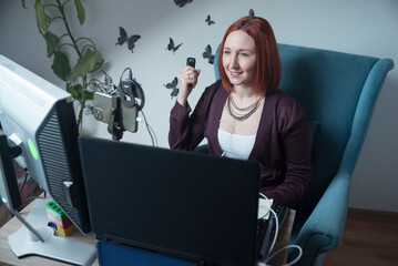 uśmiechnięta kobieta siedząca przed ekranami komputerów, podczas pracy - obrazy, fototapety, plakaty