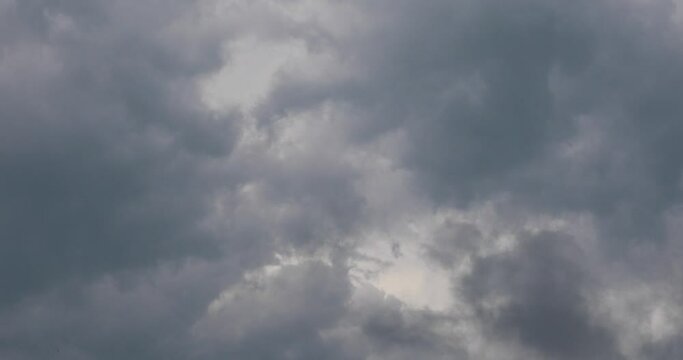 Clouds float quickly across the gloomy gray sky. Wind disperses the clouds on a rainy day