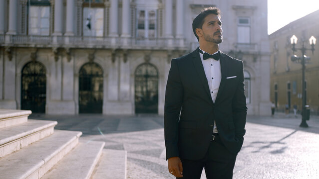 Fototapeta Elegant man in suit stands on street of European city. Action. Attractive man in elegant suit on sunny summer day. Man of dreams i suit