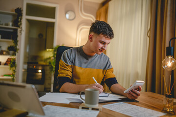 Young caucasian man teenager student study at home at the table night