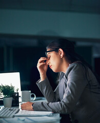 Overtime can come with headaches. Shot of a young businesswoman experiencing a headache in the...