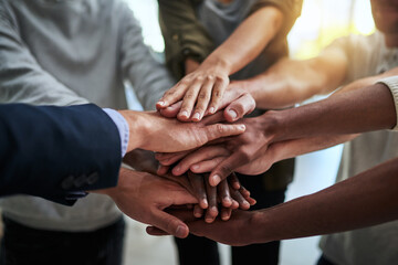 Theres nothing we cant do together. Cropped shot of a group of businesspeople joining their hands in solidarity. - obrazy, fototapety, plakaty