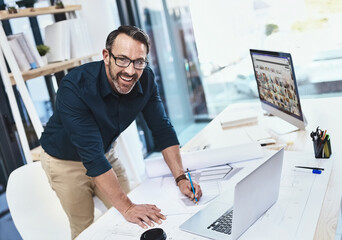 Im so inspired by the internet. Shot of a mature male architect working on his laptop.