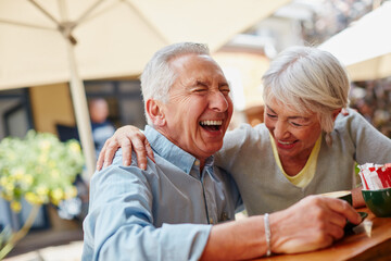 The secret to a happy marriage Live, laugh and love. Shot of a senior couple having coffee at a cafe.