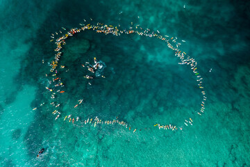 Many surfers in blue water hawaii celebration of life paddle out