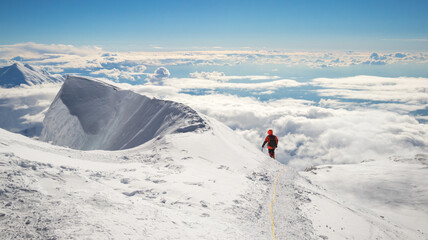 A climber enjoying panorama view on top of Mt Denali in Alaska, the highest mountain in North America, adventure concept